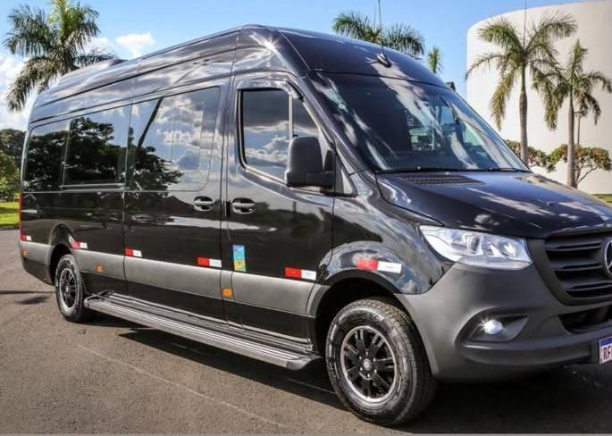 Van executiva escura da JR TOUR estacionada, usada em transfers e grupos menores.